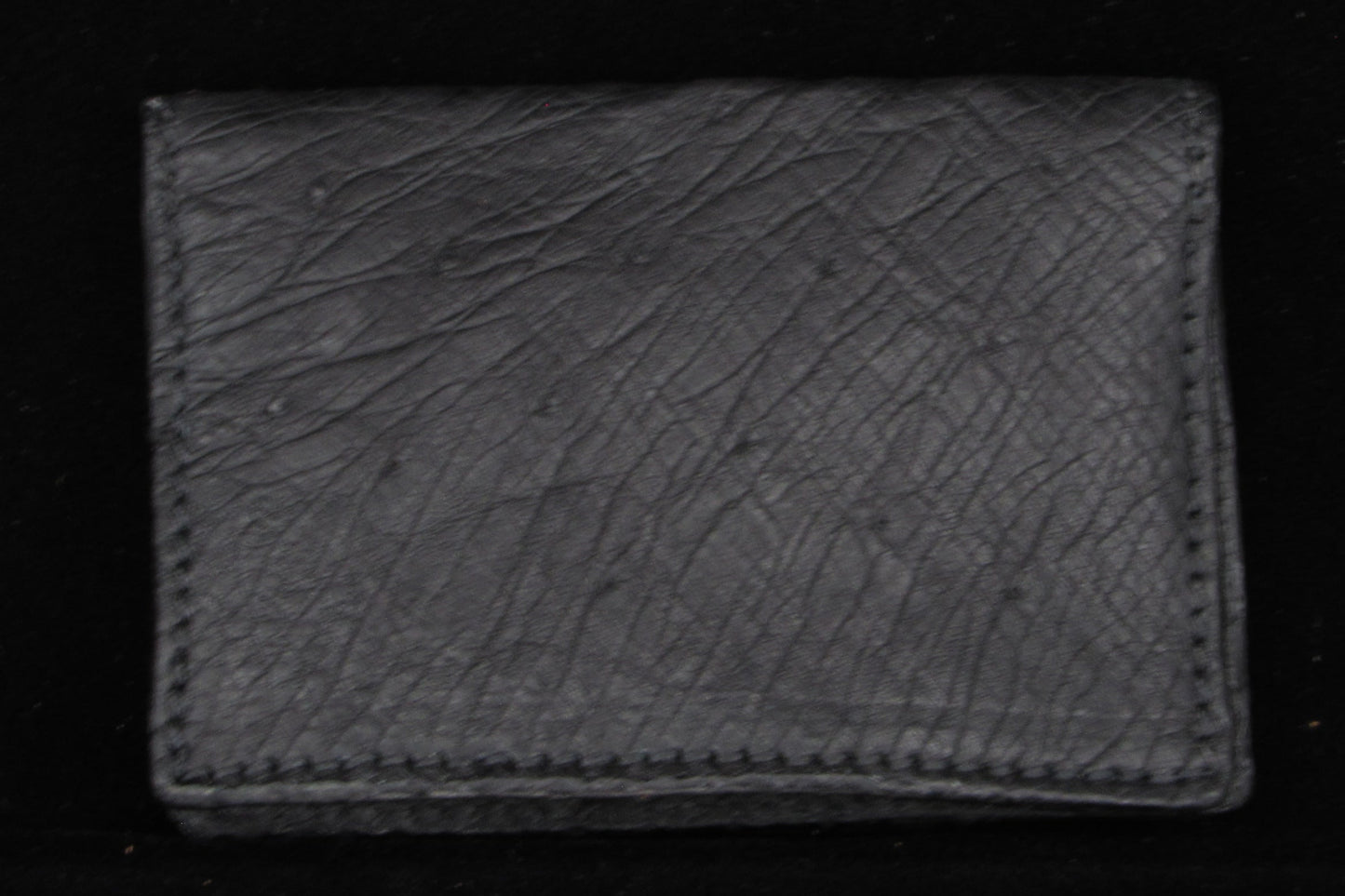 Black  ostrich leather wallet on a black background