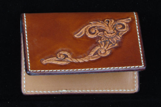 Brown leather wallet with intricate design on a black background