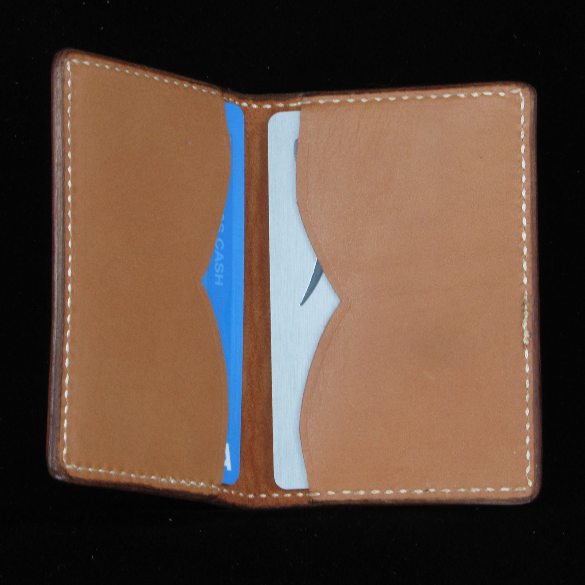 Brown leather wallet with card slots on a black background
