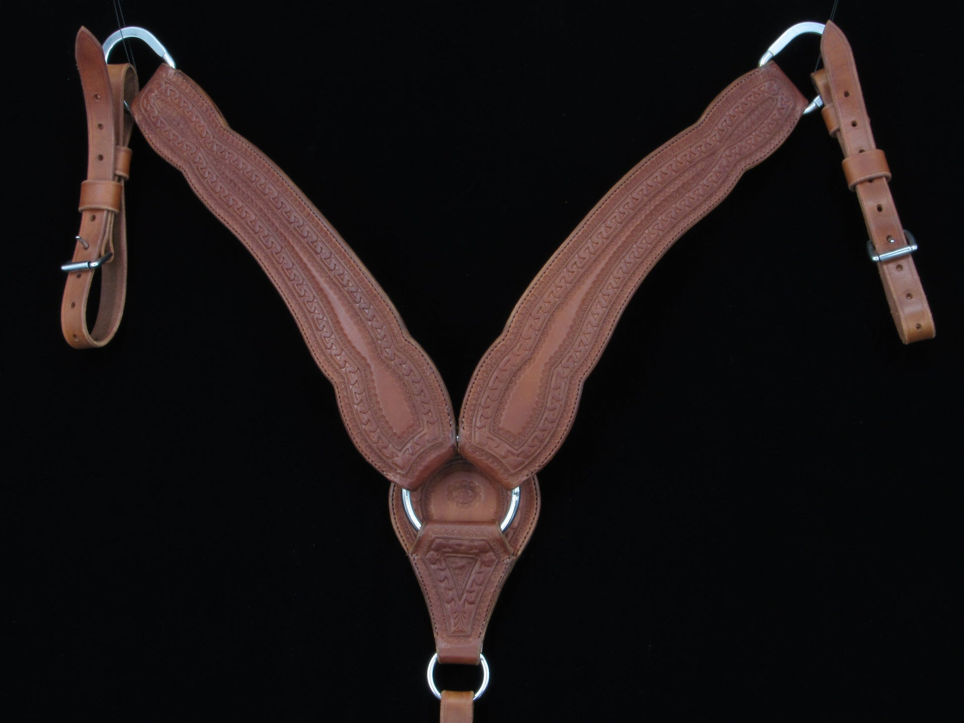 Brown leather horse saddle breastcollar on a black background
